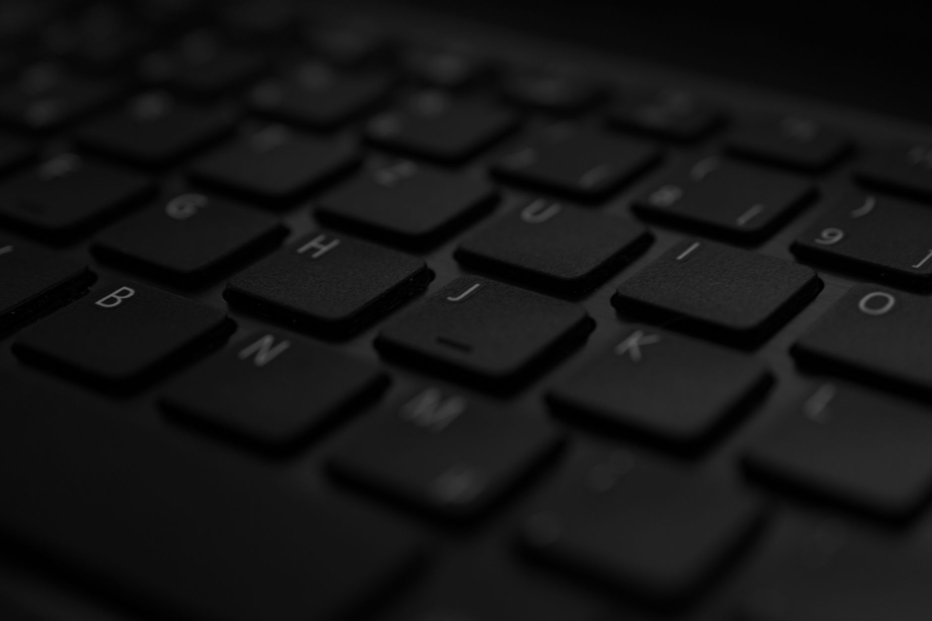 Primer plano de un teclado de portátil en un espacio de trabajo doméstico, en tono editorial.