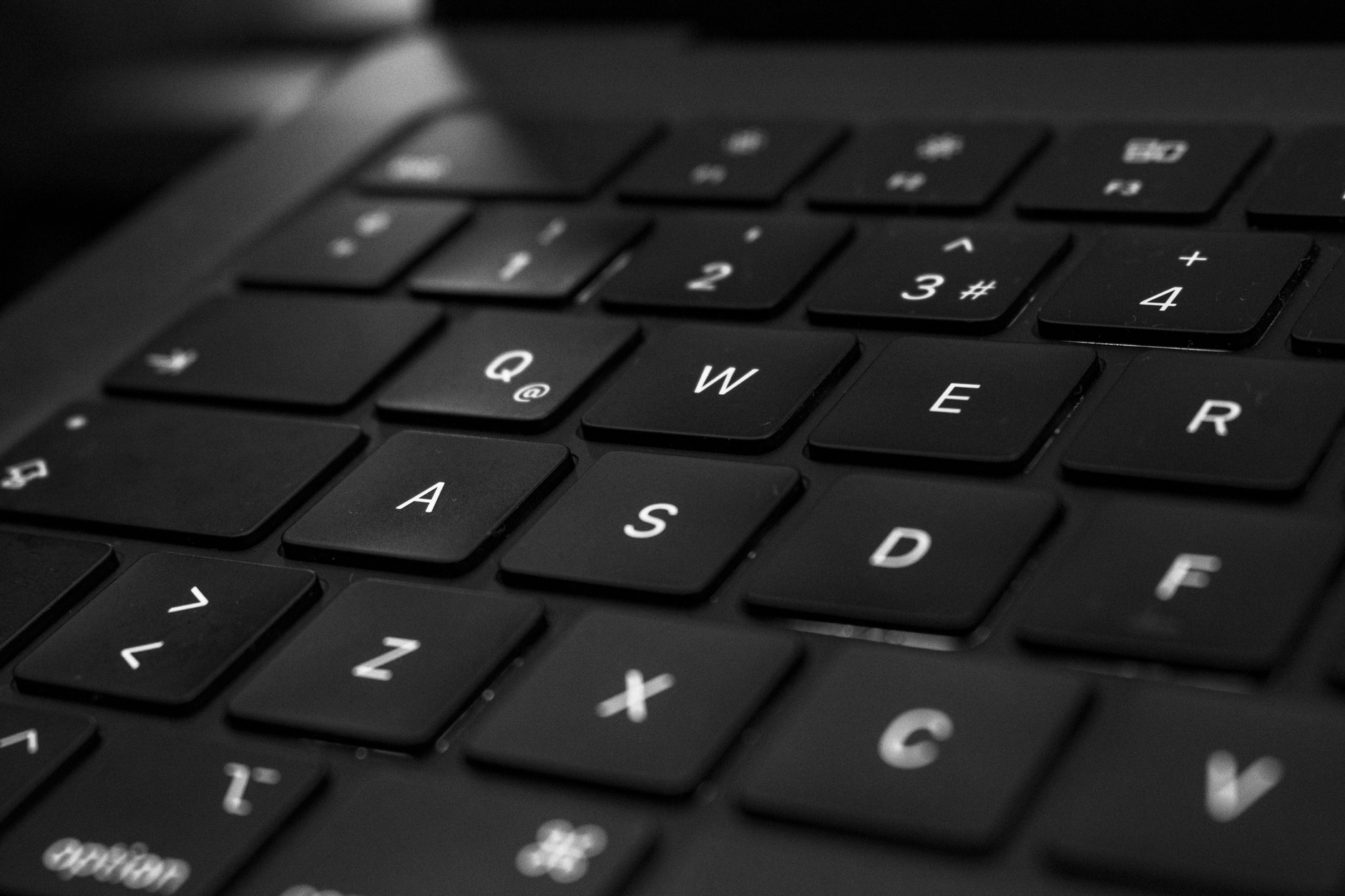 Primer plano en blanco y negro de un teclado, enfocando las teclas centrales.